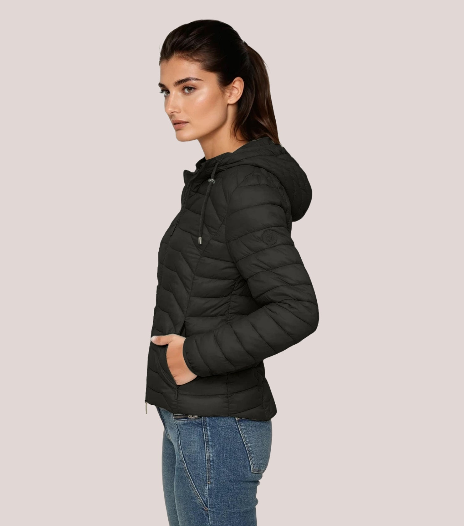 Seitenansicht Frau mit schwarzer Steppjacke und weißem T-shirt.