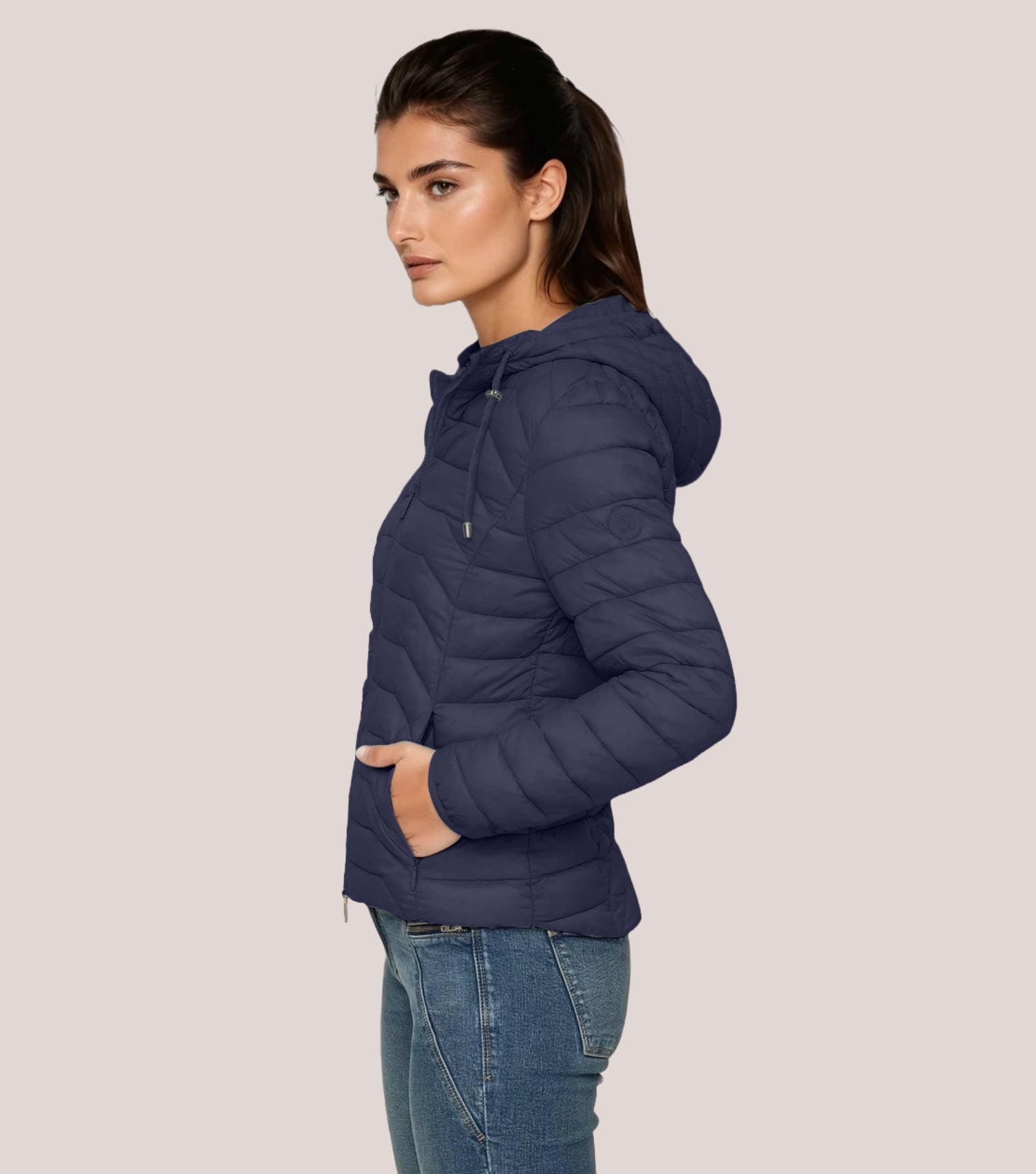 Seitenansicht Frau mit blauer Steppjacke und weißem T-shirt.