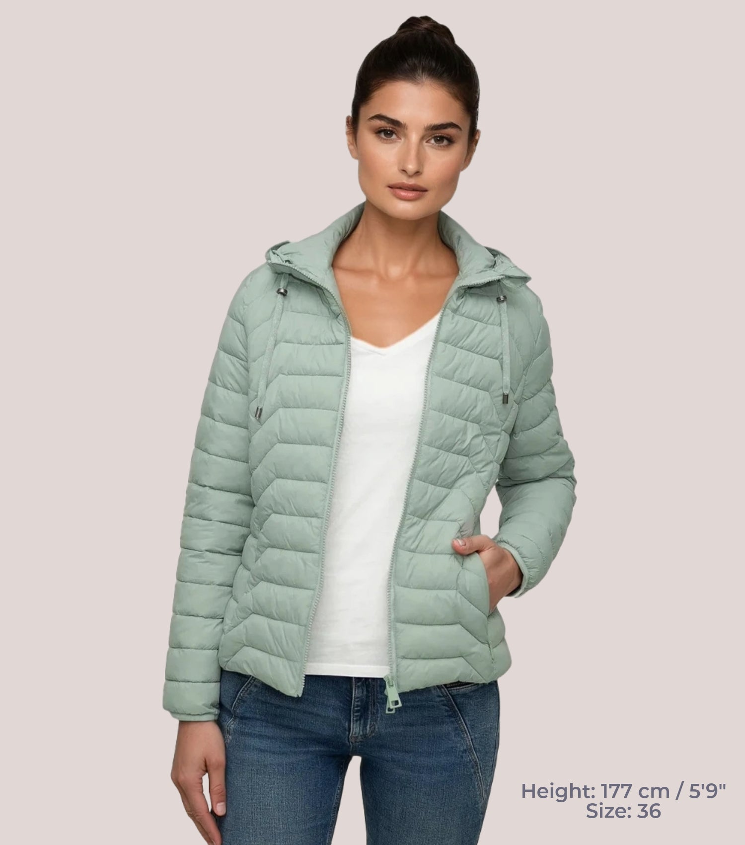 Frau mit grüner Steppjacke und weißem T-shirt. Modell ist 177cm groß und trägt Größe 36.