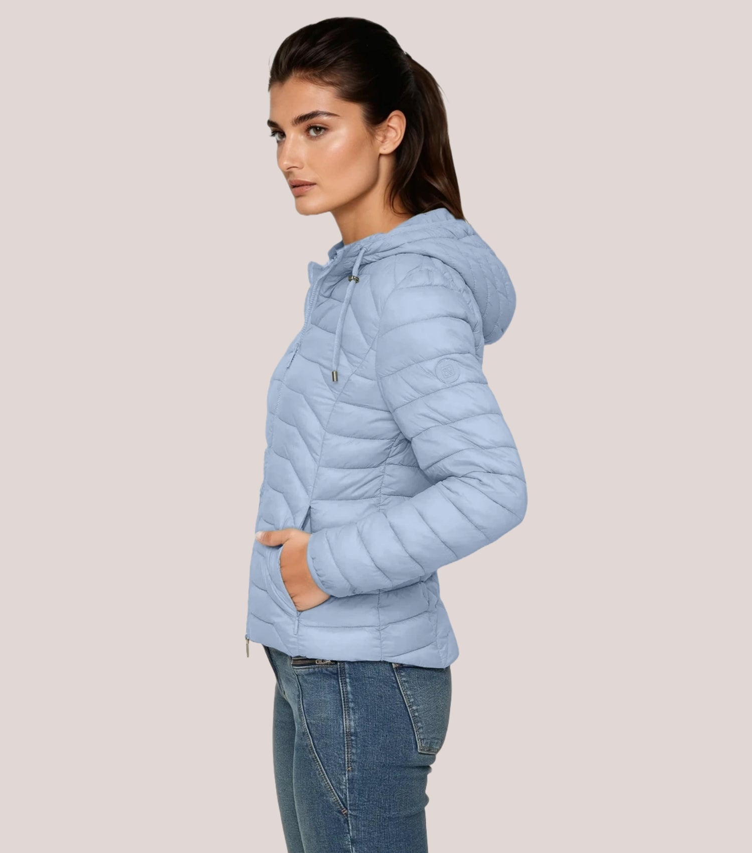Seitenansicht Frau mit blauer Steppjacke und weißem T-shirt.