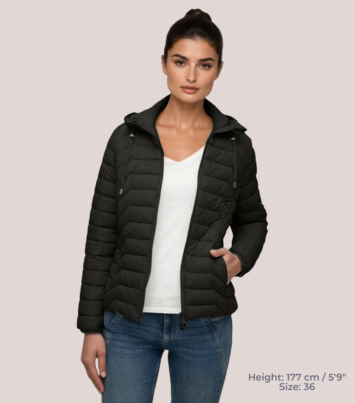 Frau mit Schwarzer Steppjacke und weißem T-shirt. Modell ist 177cm groß und trägt Größe 36.