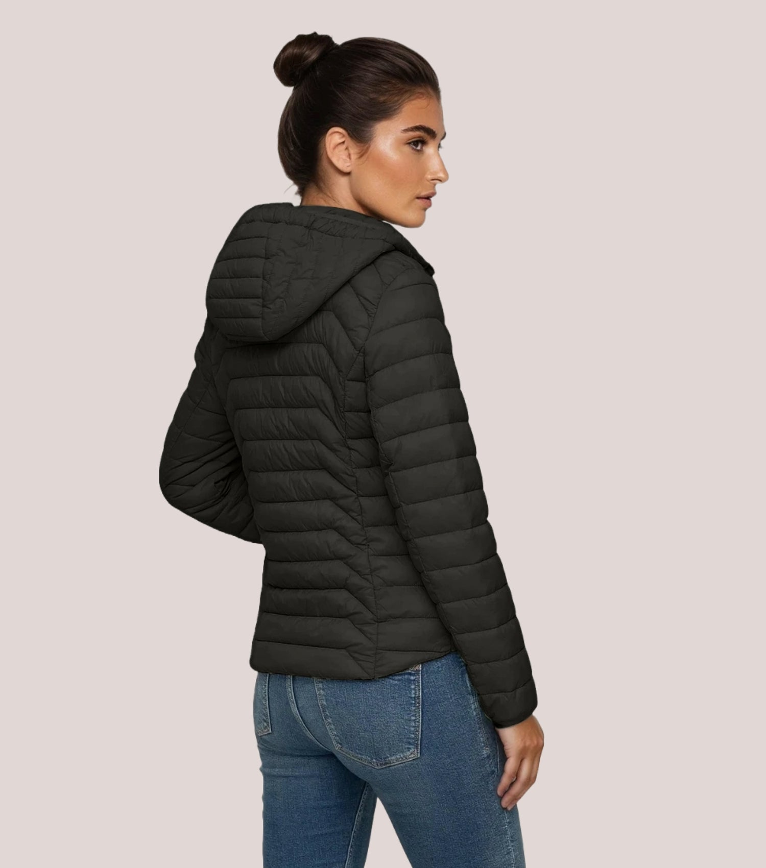 Rückansicht Frau mit schwarzer Steppjacke und weißem T-shirt.