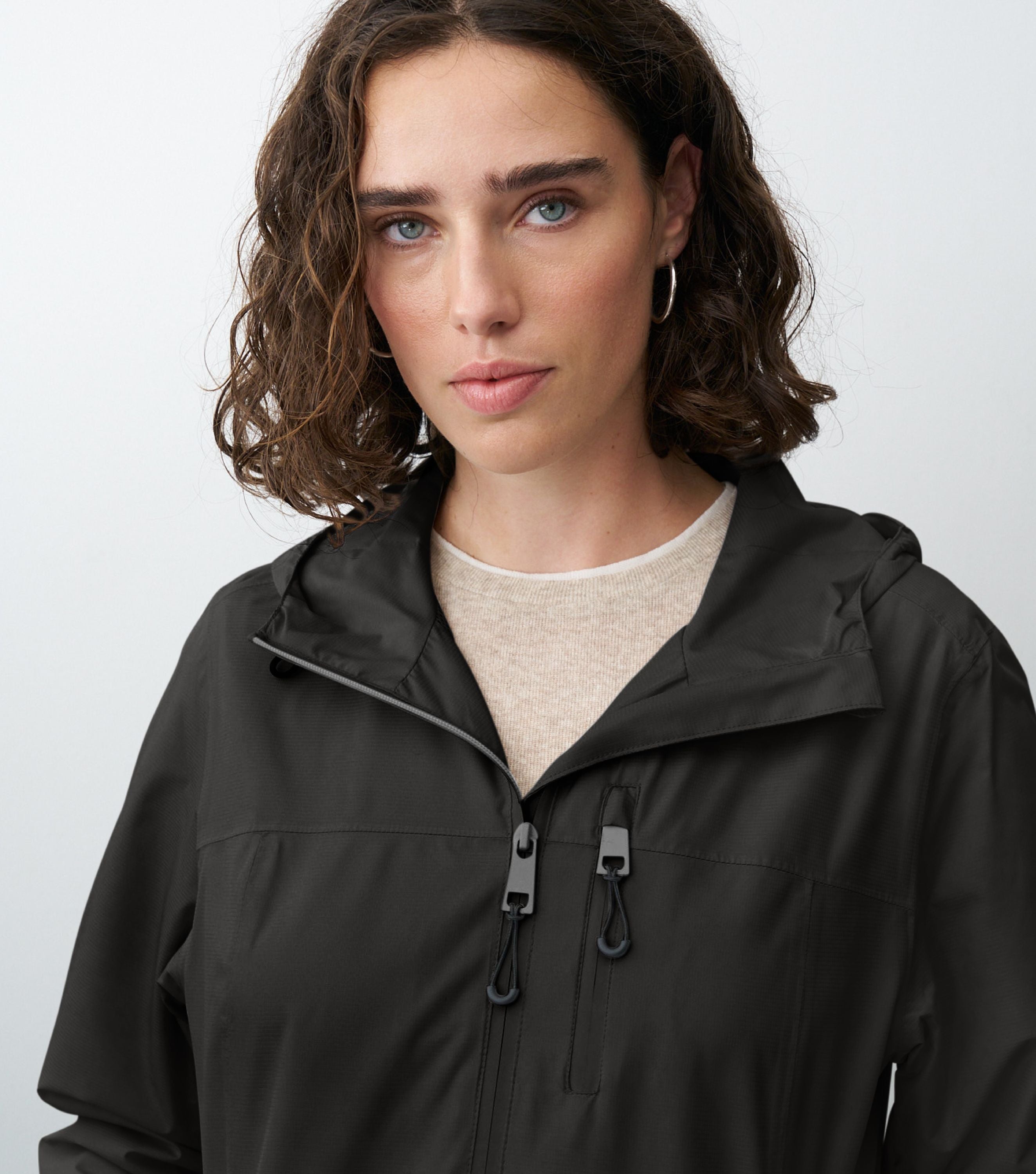 Nahansicht einer braunhaarigen Frau die eine schwarze Regenjacke trägt