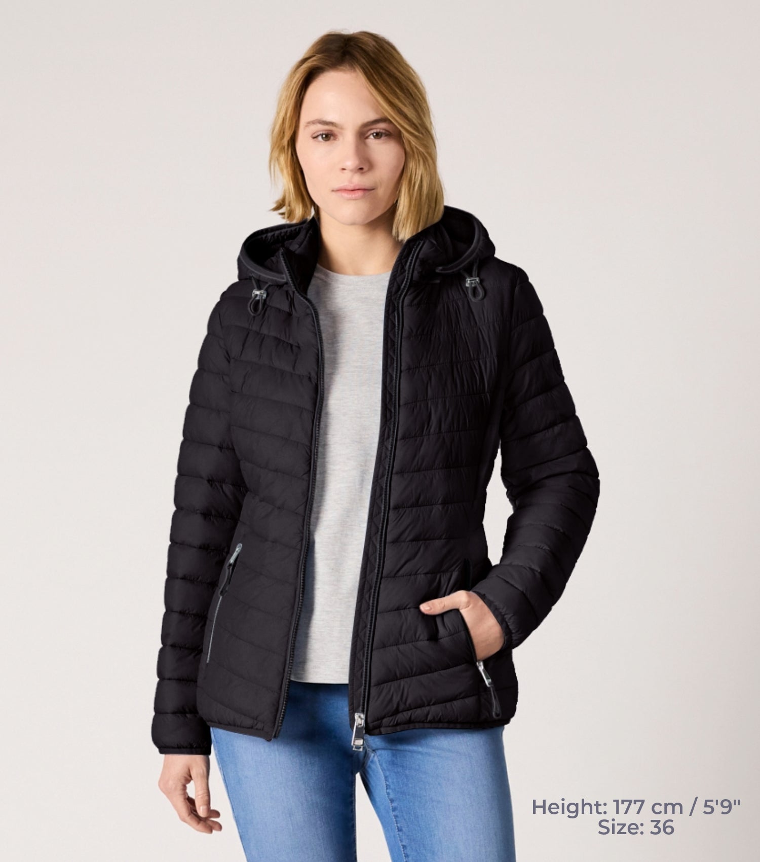 Frau mit Schwarzer Steppjacke und weißem T-shirt. Modell ist 177cm groß und trägt Größe 36. 