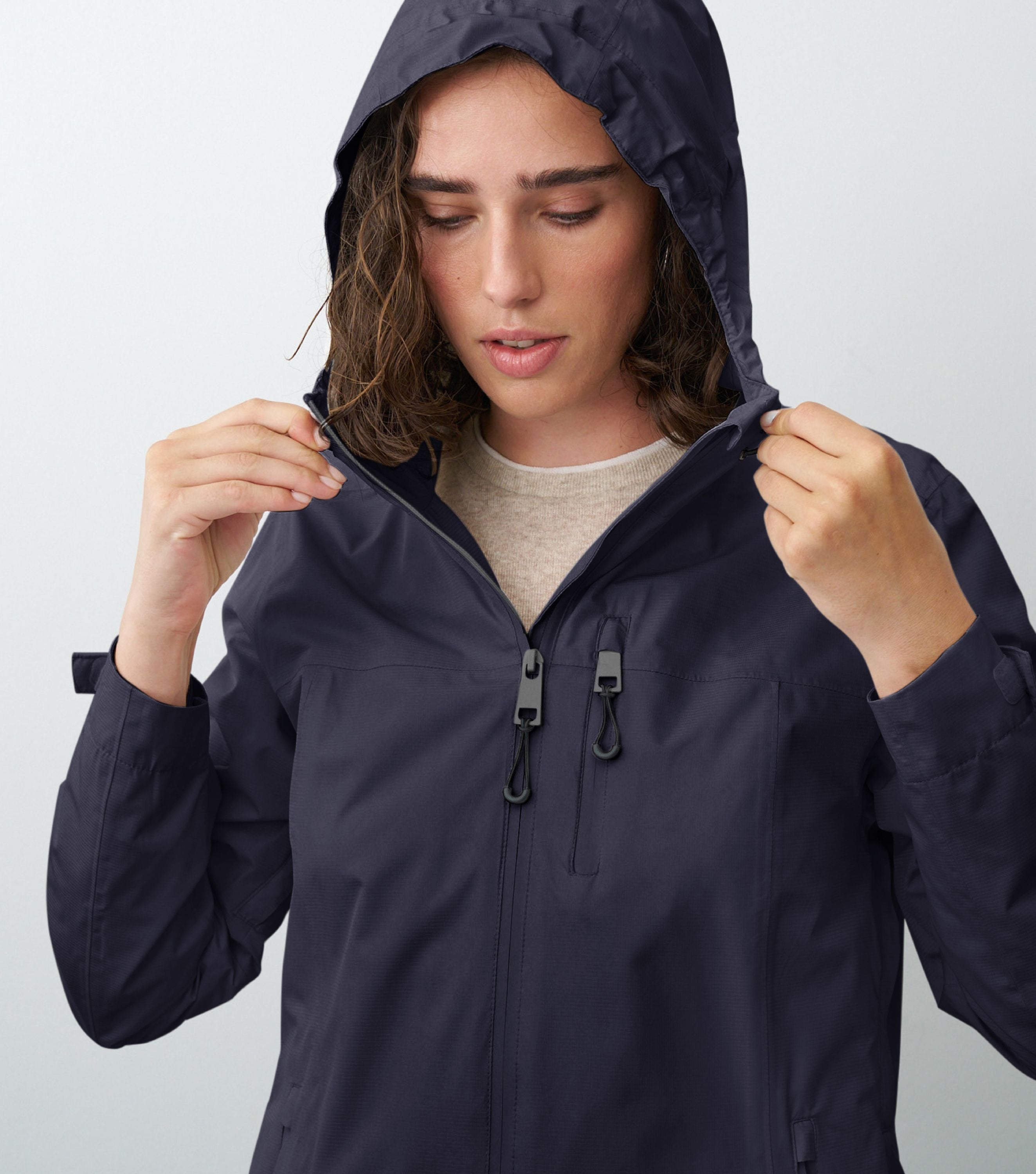 Nahansicht einer Frau die eine blaue Regenjacke trägt und die Kapuze aufhat 